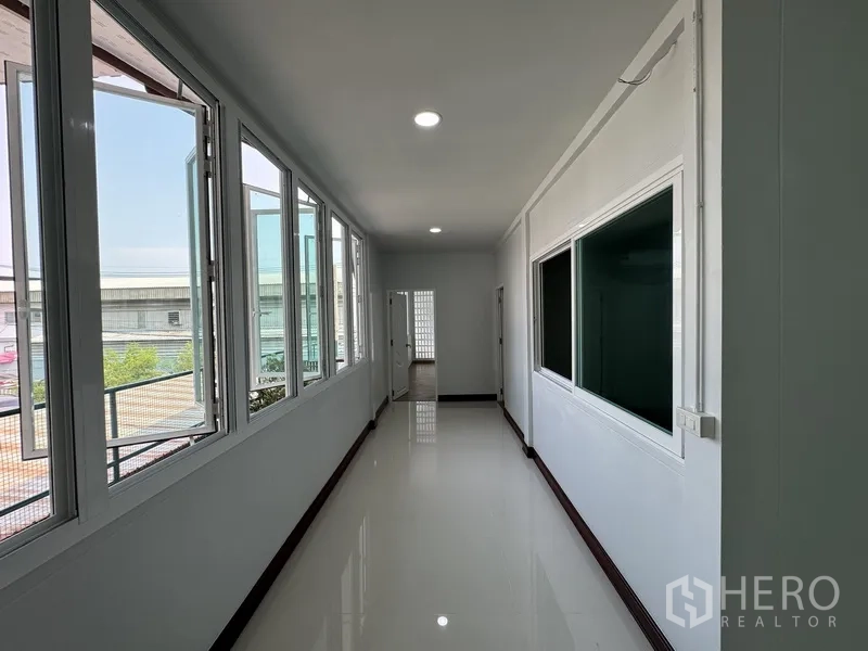 Townhouse for sale in Bueng Kum, Bangkok - View of bedroom entrances beside a glass block feature wall on the upper floor.