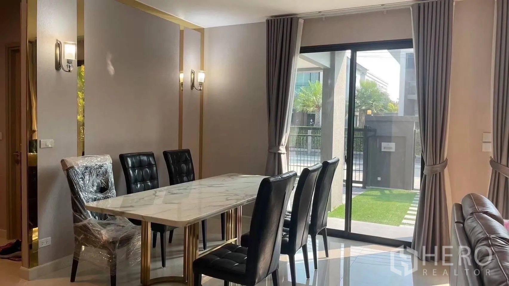 Detached House for rent in Prawet, Bangkok - Dining area with marble-top table, black chairs and sliding door to the garden.