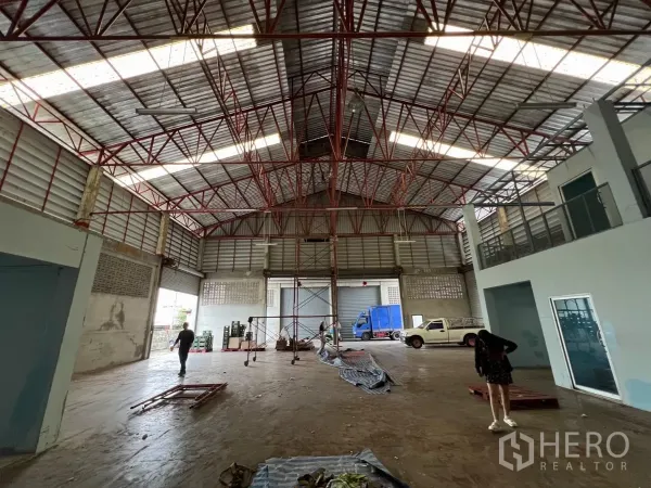 คลังสินค้า ให้เช่าในKhlong Sam Wa, Bangkok - ภายในโกดังเพดานสูง โครงเหล็กสีแดง พร้อมออฟฟิศชั้นลอยและประตูม้วนหลายจุด ในเขตคลองสามวา