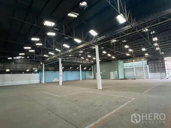 Warehouse for rent in Samut Prakan - Open warehouse bay with marked loading zones and bright skylights.