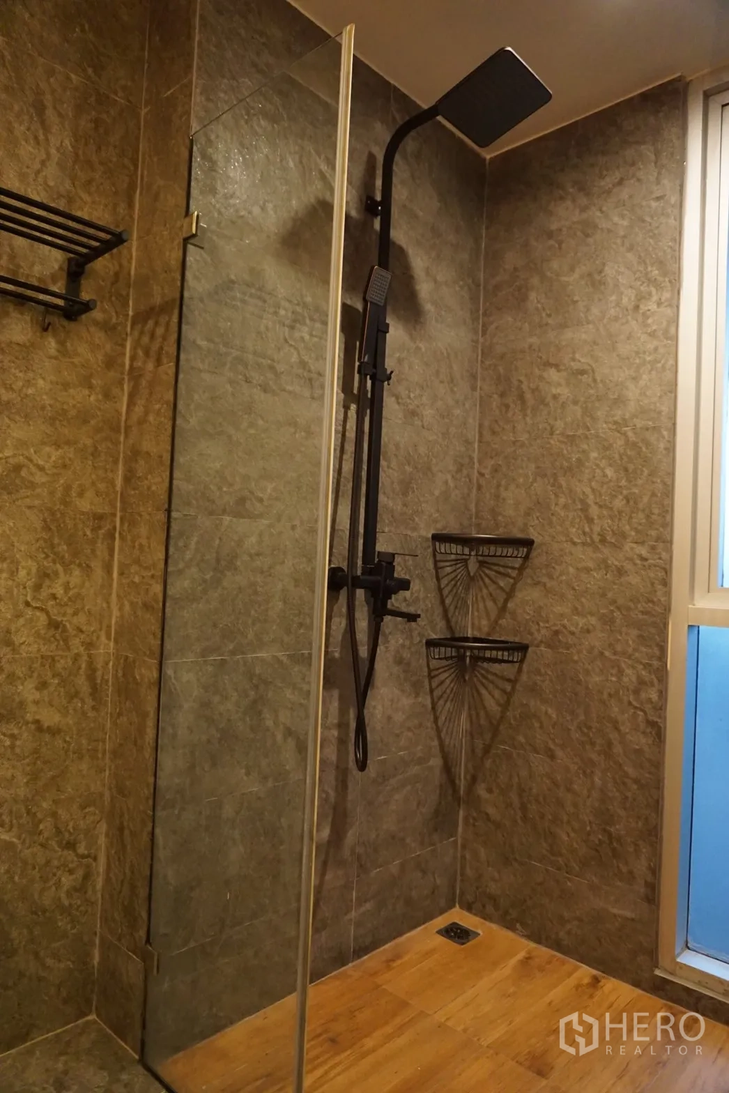 Condominium for rent or sale in Bang Rak, Bangkok - Walk-in shower with black rainfall shower, glass partition, stone-look tiles and a window for natural light.