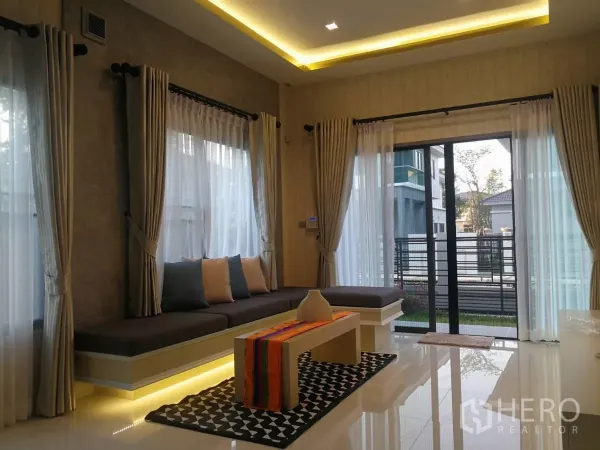 บ้าน ขายในLat Krabang, Bangkok - ห้องนั่งเล่นโปร่งสว่าง มีหน้าต่างบานใหญ่ ประตูกระจกบานเลื่อน และม้านั่งบิวท์อินพร้อมไฟซ่อน