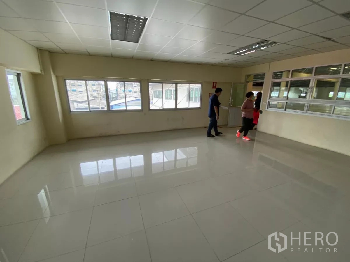 工厂 出租在Khlong Toei, Bangkok - 带瓷砖地面与吊顶的办公室，设多扇窗户俯瞰车间。