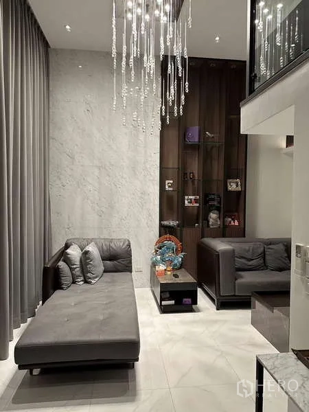 Townhouse for rent in Yan Nawa, Bangkok - Lounge with marble feature wall, display shelves and contemporary grey sofas.
