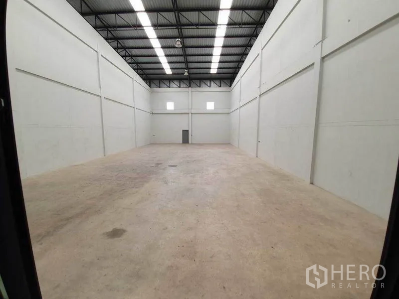 工厂 出租在Mueang Samut Sakhon, Samut Sakhon - 高挑仓储空间，混凝土地面，条形照明与通风窗，空间开阔。