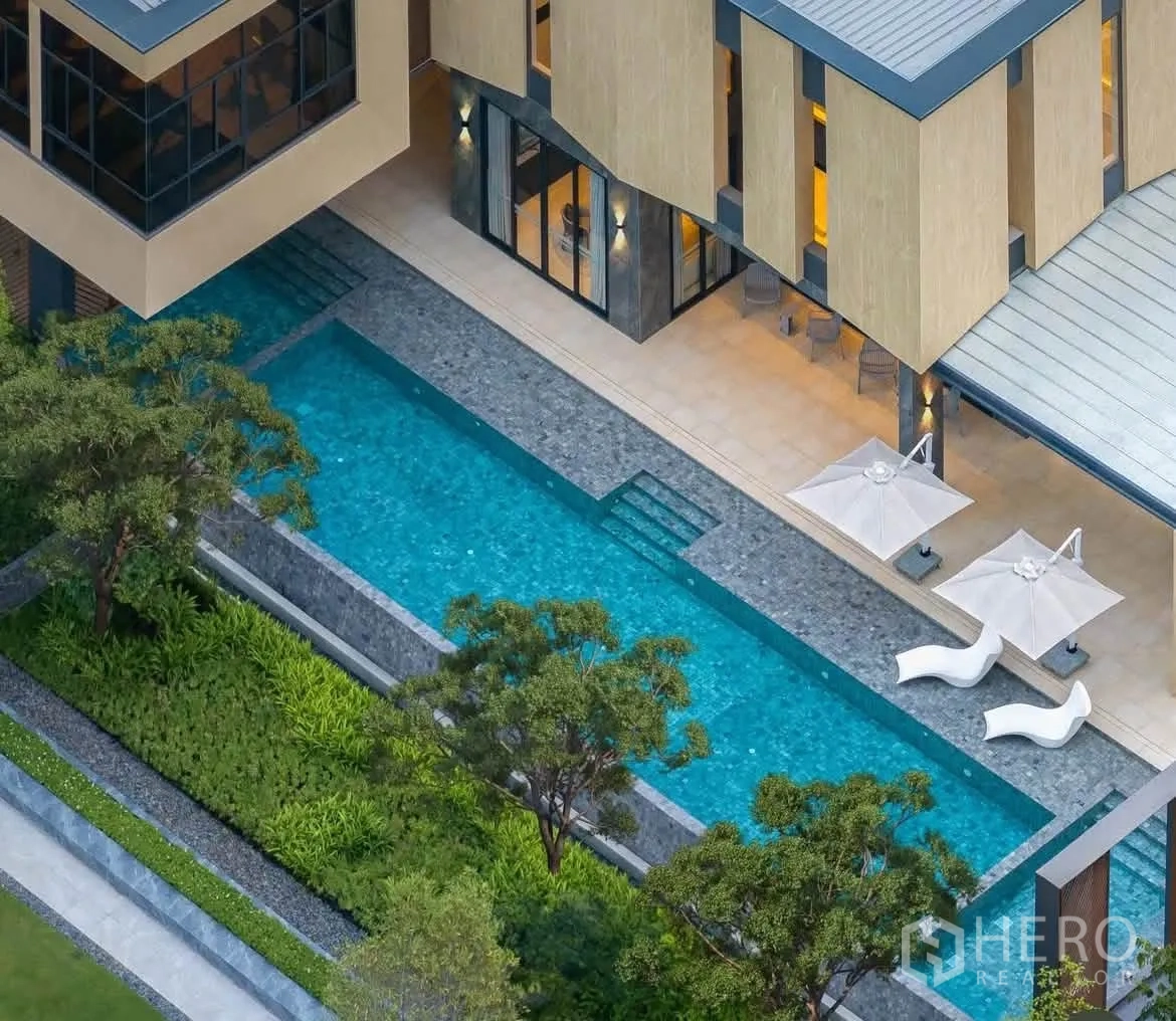 Detached House for rent in Bang Phli, Samut Prakan - Aerial view of a resort-style swimming pool beside a clubhouse terrace.