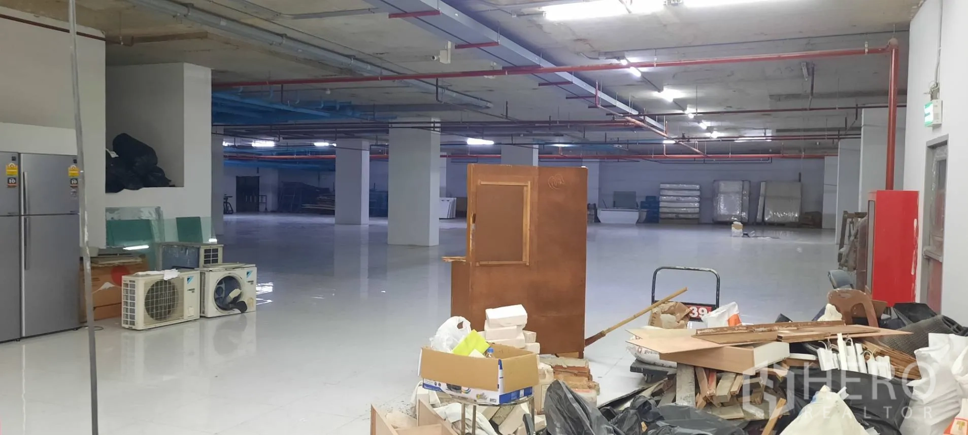 พื้นที่ขายของ for rent in Watthana, Bangkok - พื้นที่ชั้นใต้ดินปูกระเบื้องกว้าง มีเสาโครงสร้างและท่อระบบบนเพดาน