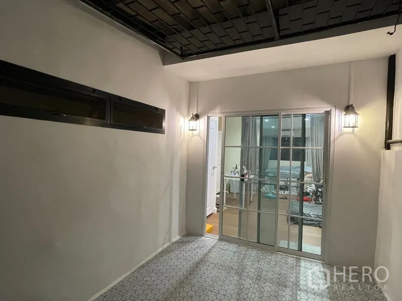 ทาวน์เฮาส์ ให้เช่าในPhra Khanong, Bangkok - ระเบียงในร่มติดโคมไฟผนัง พื้นกระเบื้องลายหกเหลี่ยม และประตูกระจกบานเลื่อน