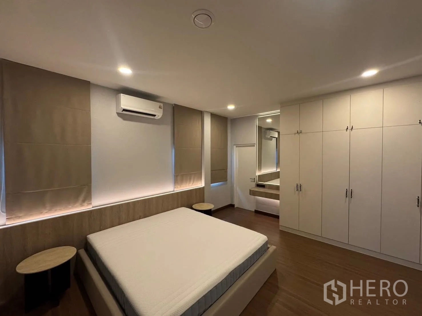 Detached House for rent in Bang Phli, Samut Prakan - Master bedroom with bed, full-height wardrobes, and lighted vanity.