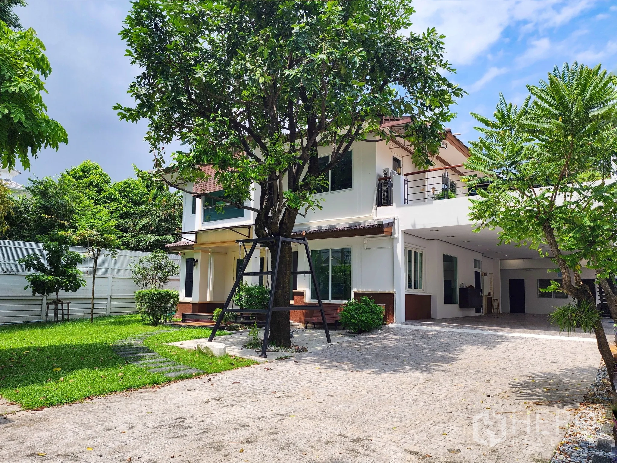 独立式住宅 出租在Bang Kapi, Bangkok - 两层独立屋，成树与草坪环绕，前方宽阔铺装车道。