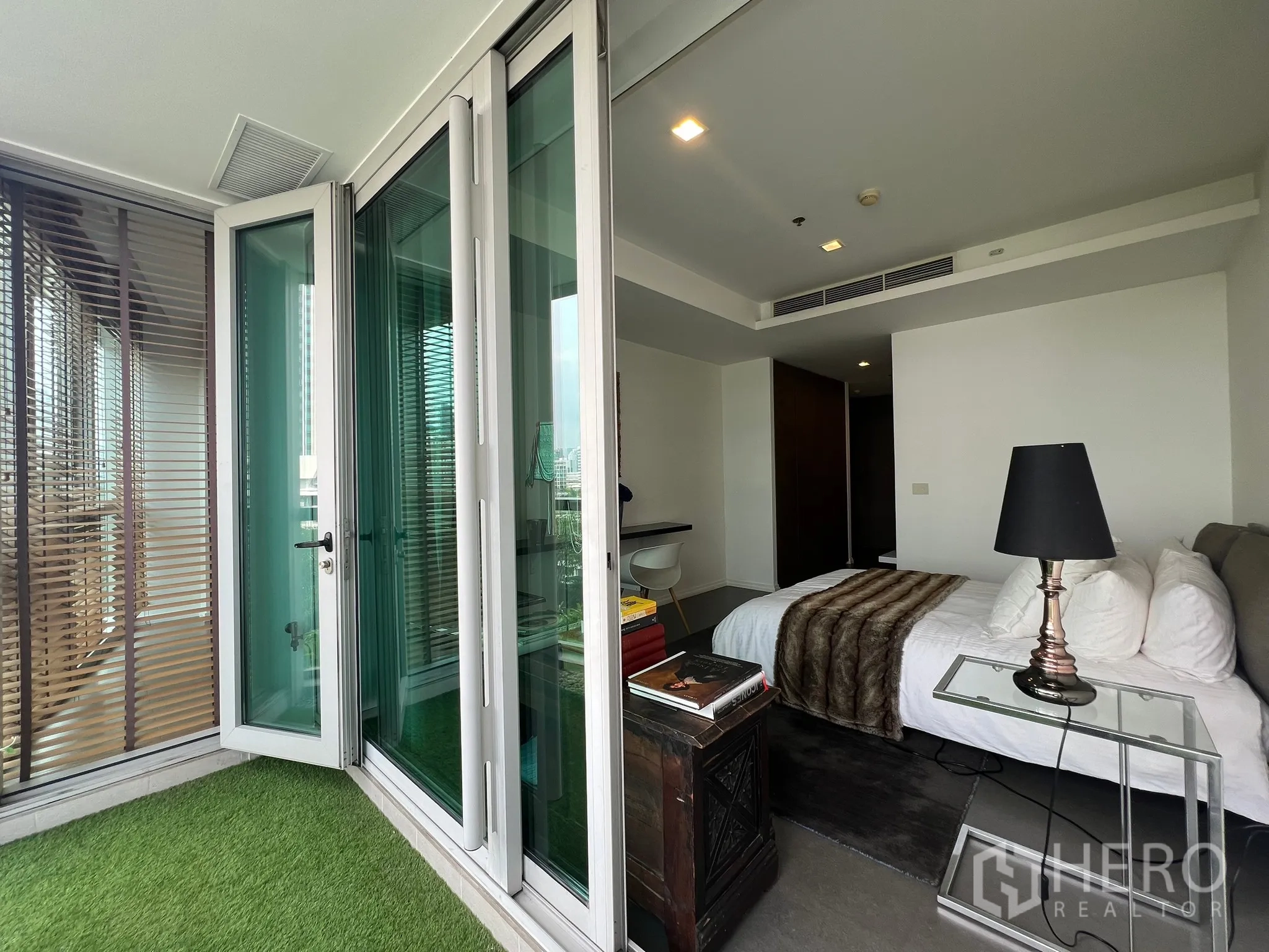 คอนโด ขายในKhlong San, Bangkok - ประตูกระจกพับจากระเบียงเข้าสู่ห้องนอน พร้อมโต๊ะข้างเตียง
