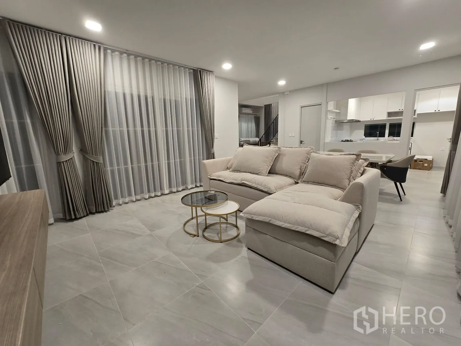 独栋房屋 for rent in Bang Phli, Samut Prakan - 开放式起居区，设沙发与叠放茶几，可见厨房。