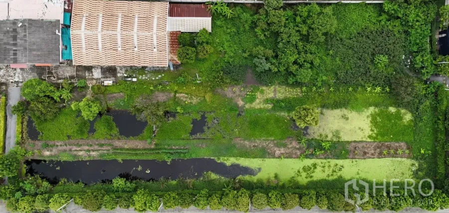 ที่ดิน ขายในKhlong Sam Wa, Bangkok - ภาพมุมสูงมองลงเห็นแปลงที่ดินสีเขียวขนาดใหญ่พร้อมบ่อน้ำและแนวต้นไม้รอบขอบเขต