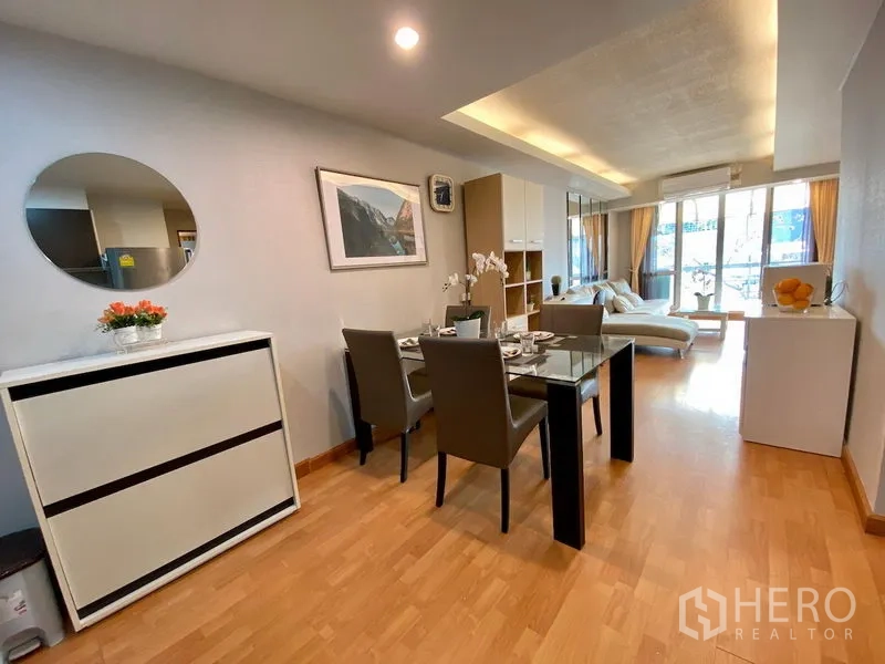 คอนโด ขายในKhlong Toei, Bangkok - พื้นที่นั่งเล่นและทานอาหารแบบโอเพ่นสเปซ โต๊ะกระจก ตู้วางของ และประตูกระจกสูงจรดเพดานออกสู่ระเบียง