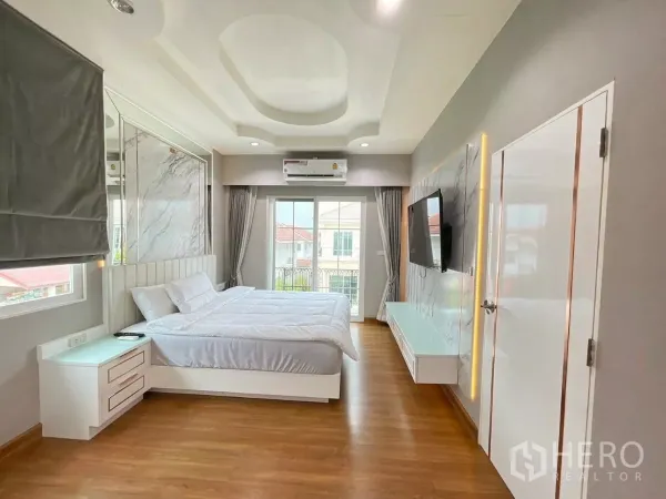 独立式住宅 出租在Bang Khen, Bangkok - 主卧配大床、阳台门、壁挂电视与造型天花。