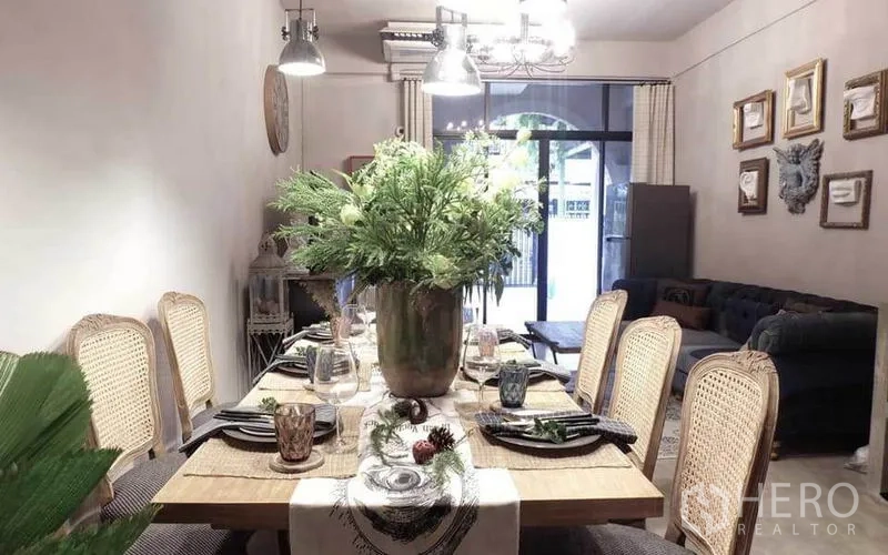 联排别墅 出租在Watthana, Bangkok - 餐厅与客厅相连，设沙发与推拉玻璃门，空间通透。