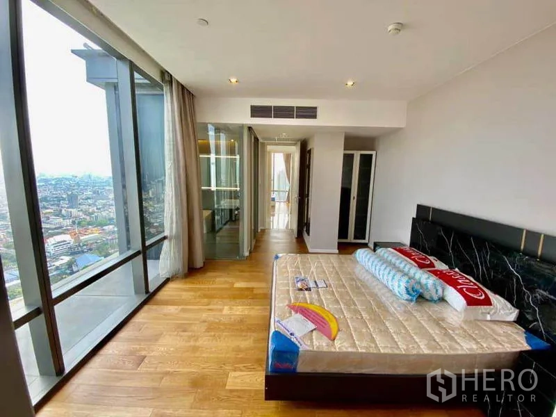 Condominium for rent in Sathon, Bangkok - Spacious master bedroom with wood flooring and a wall of windows overlooking Bangkok.