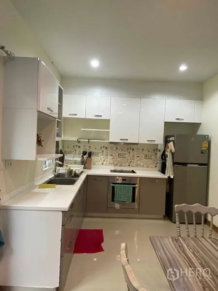 ทาวน์เฮาส์ ให้เช่าในSuan Luang, Bangkok - ภาพรวมของครัวพร้อมเตาไฟฟ้า เตาอบ ตู้เย็น และชุดโต๊ะกินข้าว