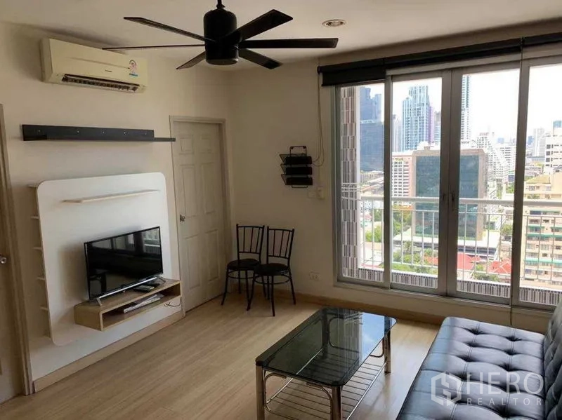 公寓 出租在Bang Rak, Bangkok - 客厅设推拉阳台门、城市景观、沙发与电视柜。