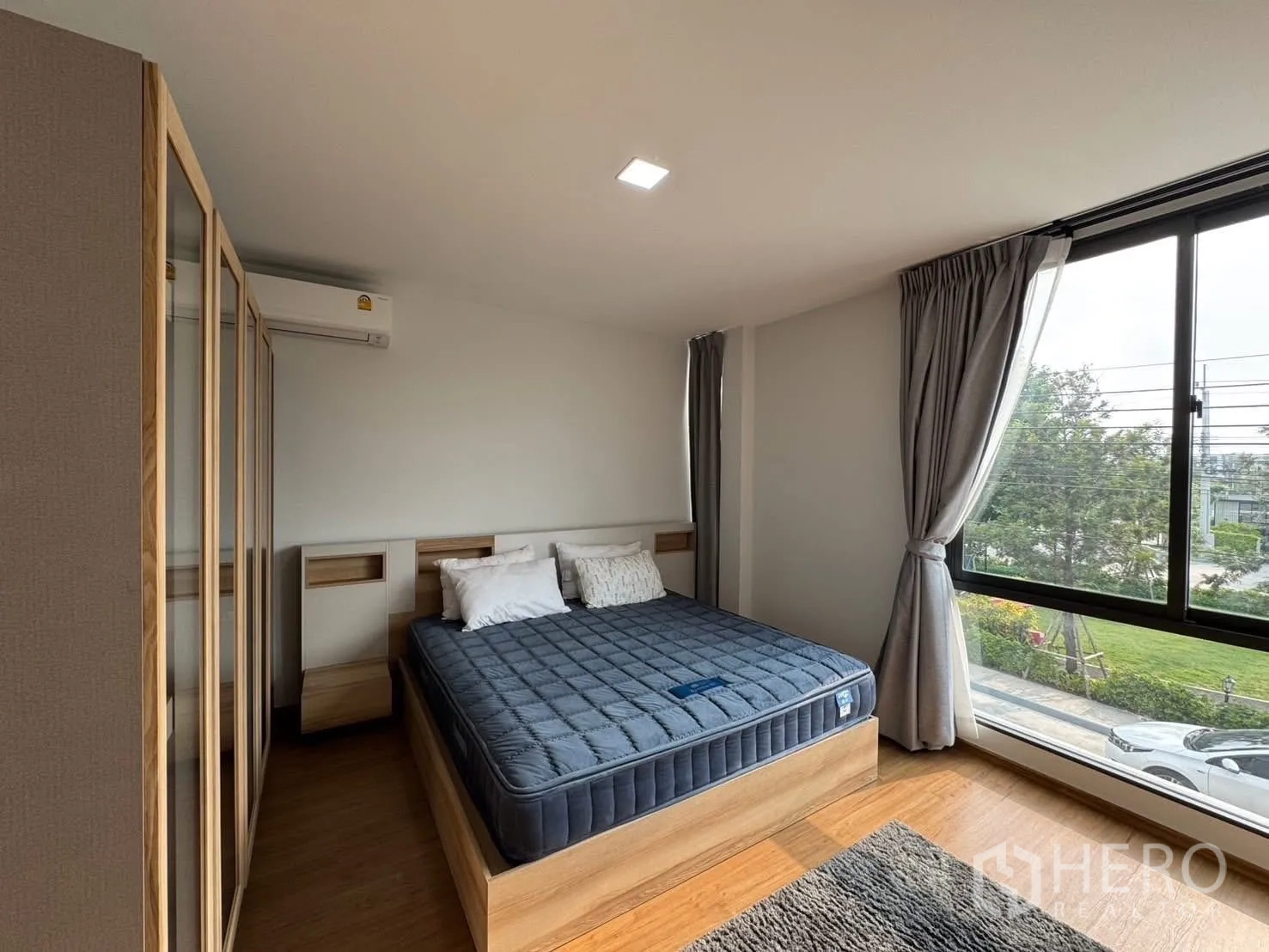 Townhouse for rent in Bang Phli, Samut Prakan - Primary bedroom with large windows, bedside units, and a neatly made bed.