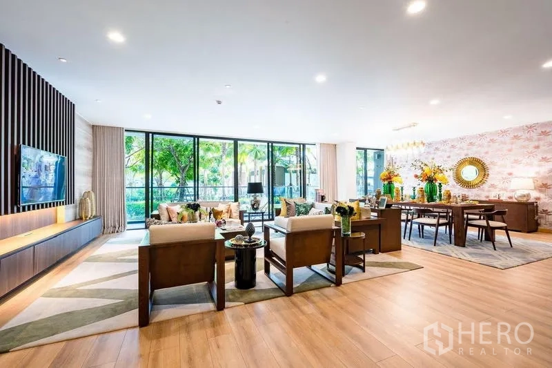 Condominium for sale - Expansive living and dining area facing a green garden through full-height sliding glass doors.