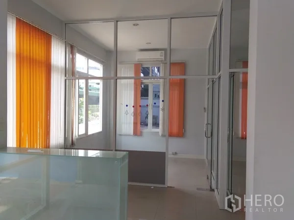 Factory for sale in Lam Luk Ka, Pathum Thani - Reception-style office room with floor-to-ceiling windows and orange blinds.