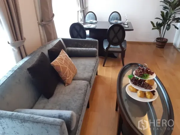 คอนโด ให้เช่าในWatthana, Bangkok - ห้องนั่งเล่นพร้อมโซฟา โต๊ะอาหาร กระถางต้นไม้ และพื้นไม้โทนอุ่น