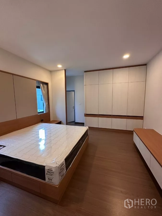 Detached House for rent in Bang Phli, Samut Prakan - Bedroom with king-size bed, built-in wardrobes, and wood floors.