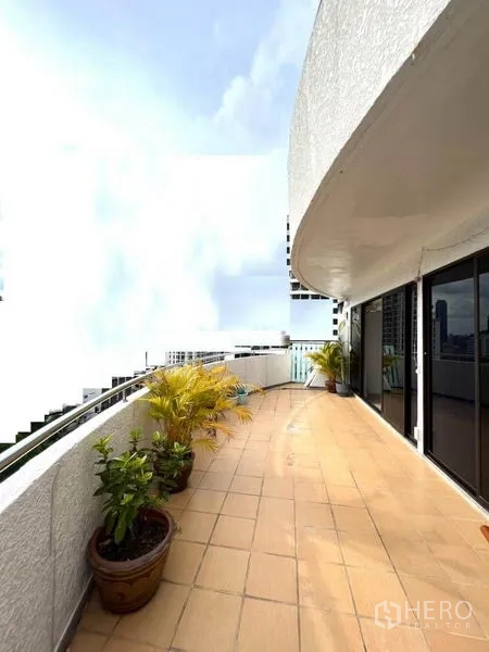 คอนโด ให้เช่าในWatthana, Bangkok - ระเบียงโค้งยาวพร้อมกระถางต้นไม้และวิวเมือง ข้างประตูกระจกบานเลื่อน