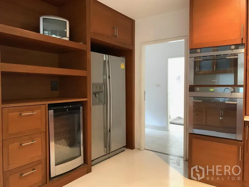 公寓 出售在Khlong Toei, Bangkok - 厨房收纳墙，双开门冰箱、酒柜与双烤箱