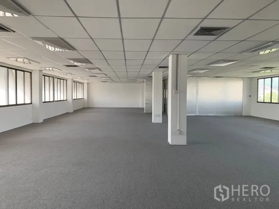 Office Space for rent in Bang Kapi, Bangkok - Spacious open-plan office floor with carpeted flooring, grid ceiling, air-conditioning vents and long rows of windows providing natural light in Bang Kapi, Bangkok.