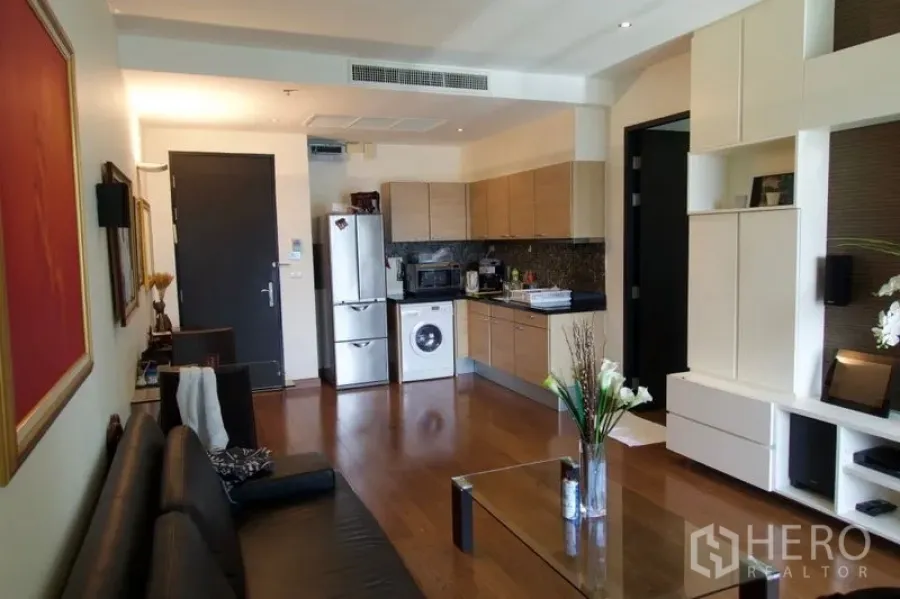 คอนโด ขายในPathum Wan, Bangkok - ห้องนั่งเล่นแบบโอเพนแปลน พื้นไม้ พร้อมชั้นบิลท์อินและครัวขนาดกะทัดรัดมีเครื่องซักผ้า