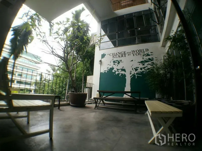 办公空间 出租在Phra Khanong, Bangkok - 户外露台，长椅、盆栽与励志墙面涂鸦。