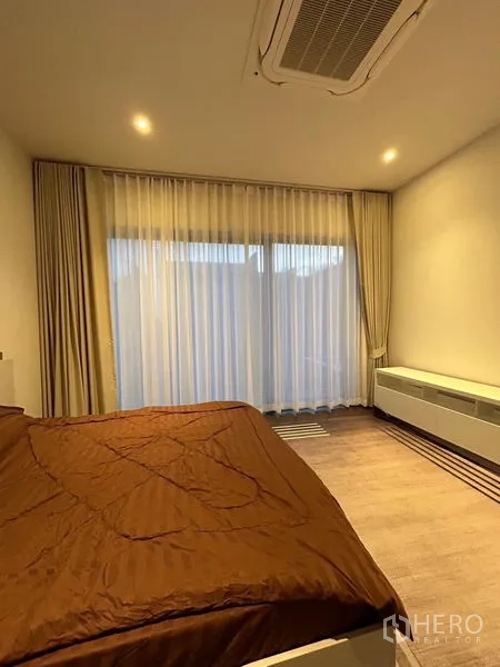 Detached House for rent in Bang Kapi, Bangkok - Cozy bedroom with large window, ceiling cassette air‑con and long console
