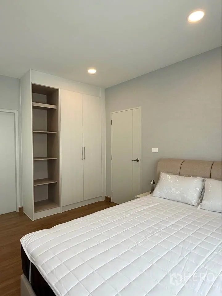 Detached House for rent in Bang Phli, Samut Prakan - Bright bedroom with bed and built-in wardrobe and open shelves.