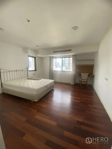 Condominium for rent or sale in Watthana, Bangkok - Bright bedroom with mattress, hardwood flooring, desk and windows allowing natural light.