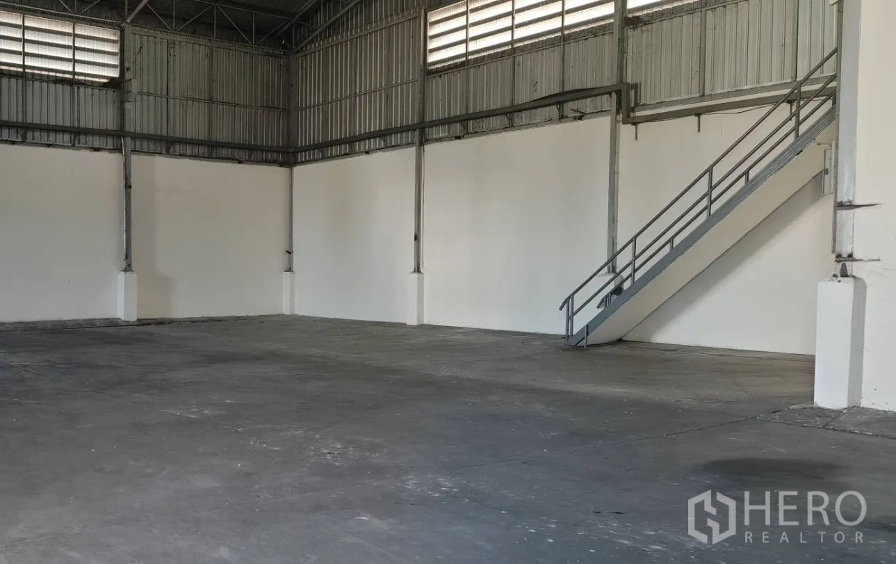 工厂 出租在Lat Lum Kaeo, Pathum Thani - 工业大厅，钢结构与混凝土地面，楼梯通向夹层办公室。