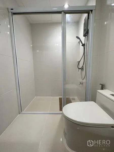 Townhouse for rent in Chom Thong, Bangkok - Shower room with sliding glass enclosure, handheld shower and toilet.