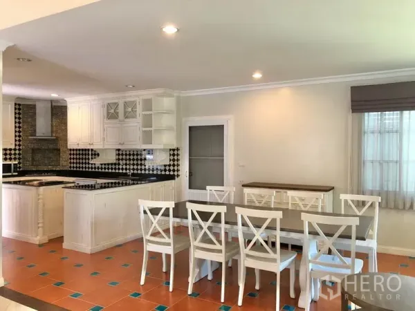 独立式住宅 出租在Mueang Samut Prakan, Samut Prakan - 餐厨一体空间，红陶地砖点缀蓝色，长餐桌与白色餐椅