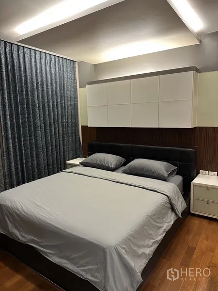 Condominium for rent in Watthana, Bangkok - Bedroom with king bed, wall-mounted cabinets, cove lighting and heavy curtains.