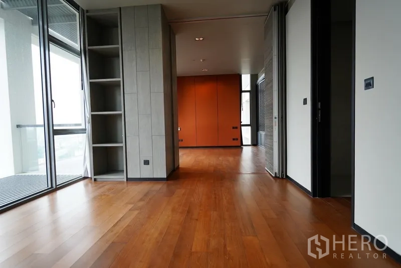 公寓 出租在Sathon, Bangkok - 宽阔套房空间，木地板、开放层架、推拉门并连接阳台。