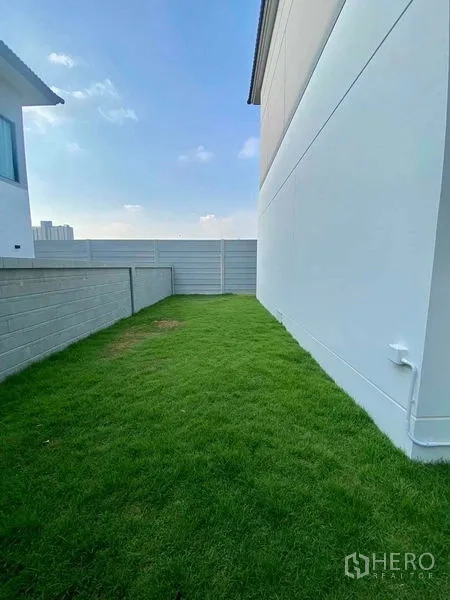 Detached House for rent or sale in Bang Phli, Samut Prakan - Private backyard lawn with high privacy walls and open sky.
