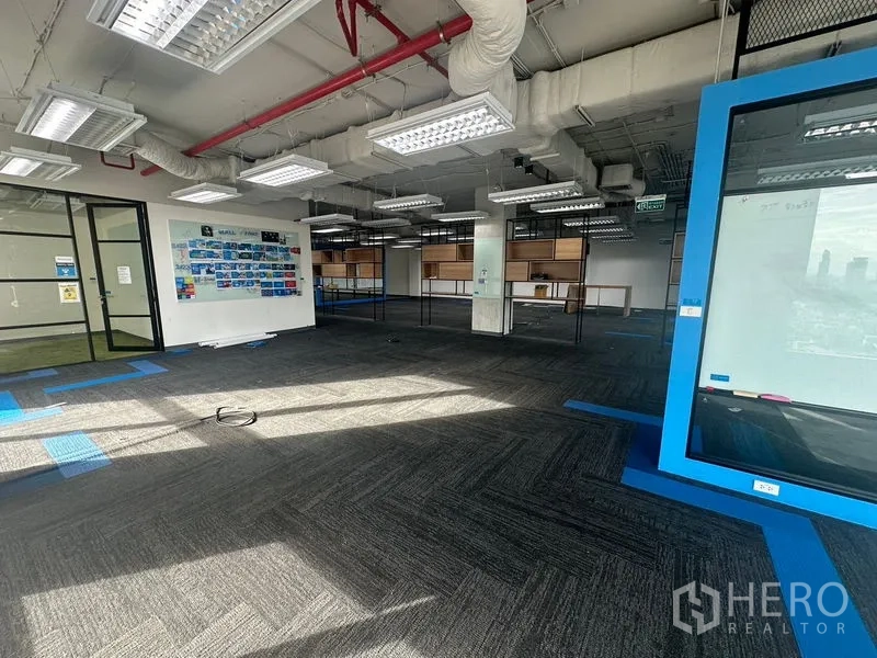 Office Space for rent in Bang Rak, Bangkok - Bright office zone with a blue display frame, shelving, and glass partitions.