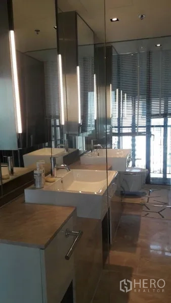 Condominium for sale in Sathon, Bangkok - Contemporary bathroom featuring double vanities, full-height mirrors and window.