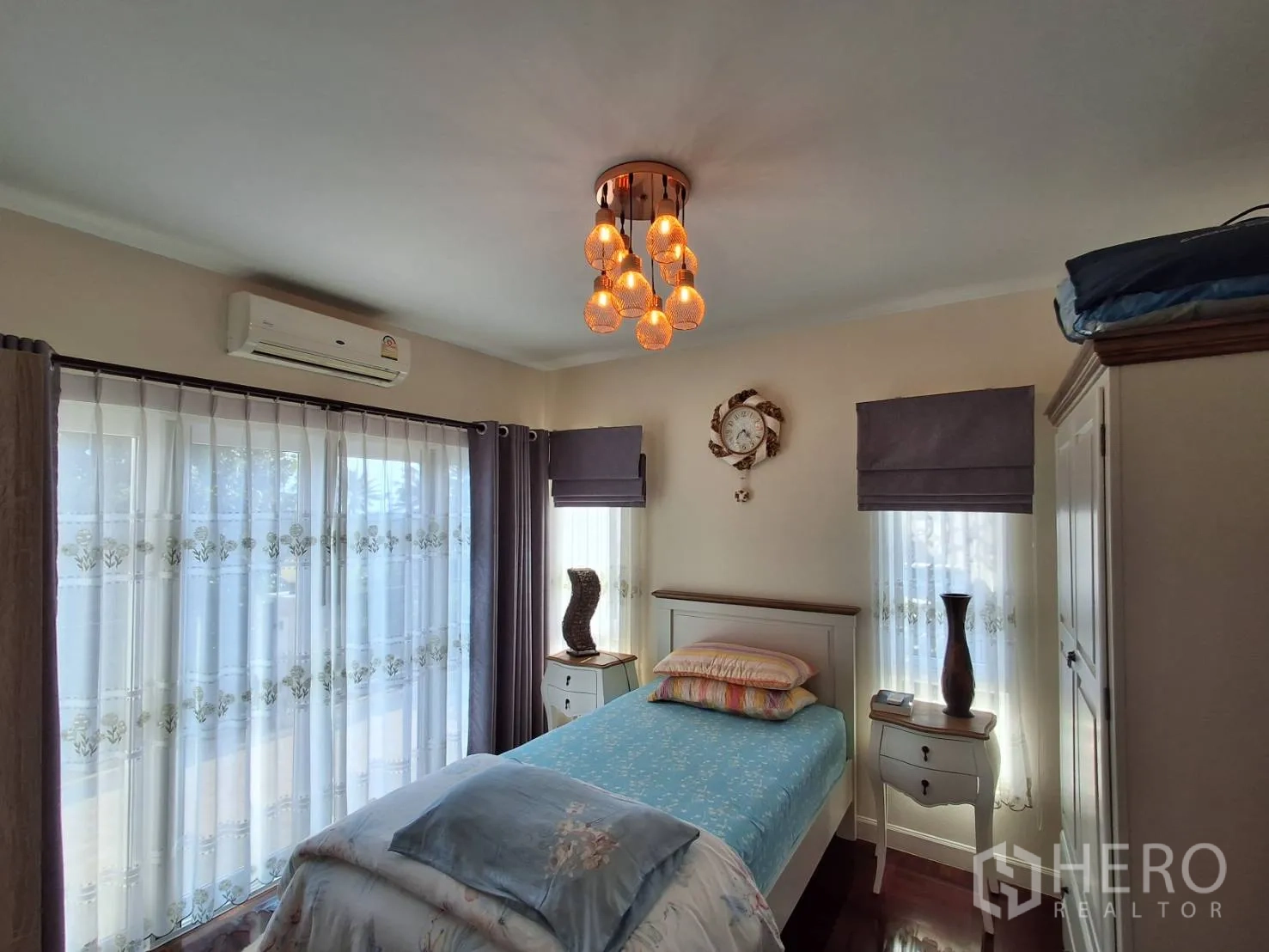 Detached House for rent or sale in Ban Chang, Rayong - Bright bedroom with single bed, bedside tables, corner windows and air conditioning.