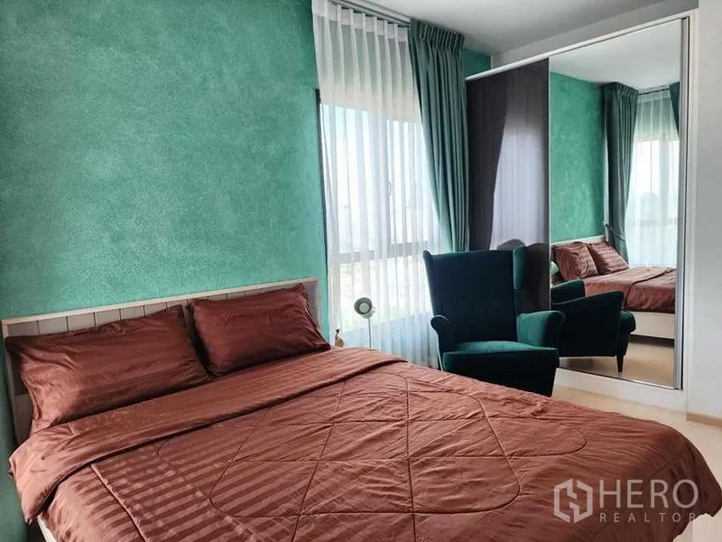 公寓 出租 - 主卧带镜面衣柜、绿色窗帘与扶手椅。