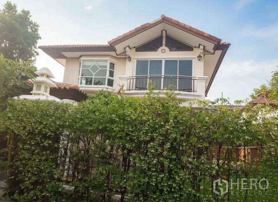 บ้าน ให้เช่าในLat Krabang, Bangkok - บ้านเดี่ยวสองชั้นย่านลาดกระบัง มีระเบียง หลังคากระเบื้อง และรั้วไม้พุ่มด้านหน้า