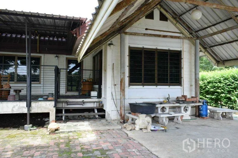 Land for sale in Khlong Luang, Pathum Thani - Corner of a house with covered patio, steps and brick paving.