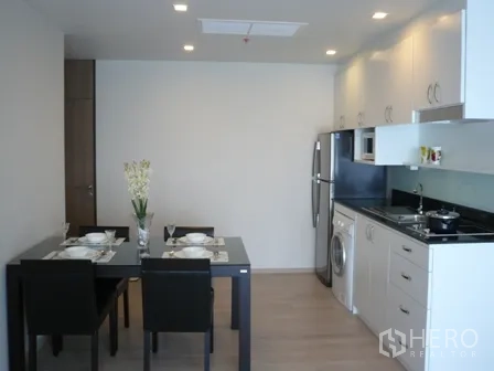 公寓 出租在Watthana, Bangkok - 开放式餐厨区，餐桌、冰箱与一体化橱柜。