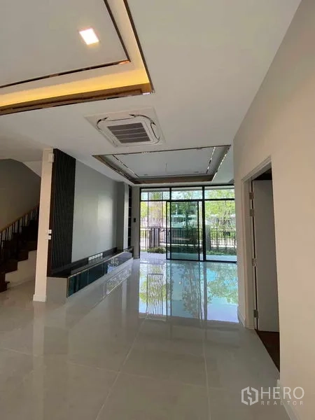Detached House for sale in Don Mueang, Bangkok - Ground-floor living space with large sliding doors opening to the front patio and garden.